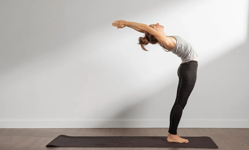 A yoga practitioner demonstrates proper chest extension and safe shoulder alignment in Hasta Uttanasana Raised Arms Pose.