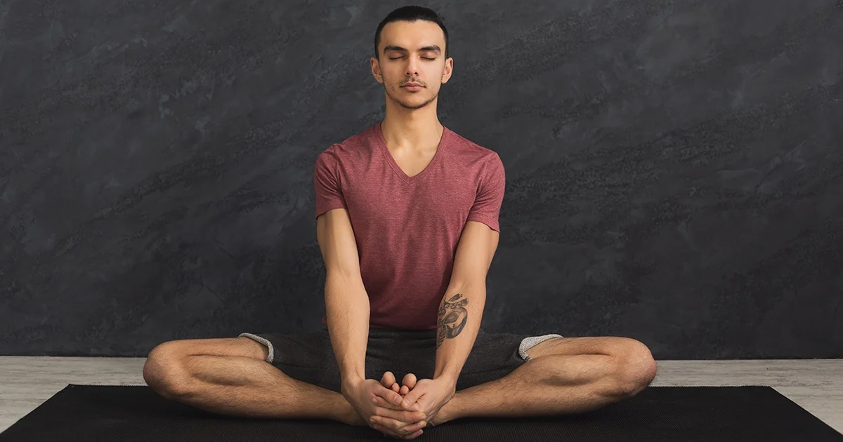 A yoga practitioner keeping a long spine and level pelvis while demonstrating safe alignment in Baddha Konasana.