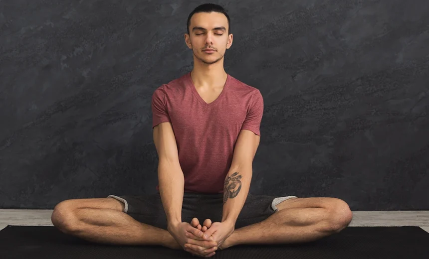 A yoga practitioner keeping a long spine and level pelvis while demonstrating safe alignment in Baddha Konasana.