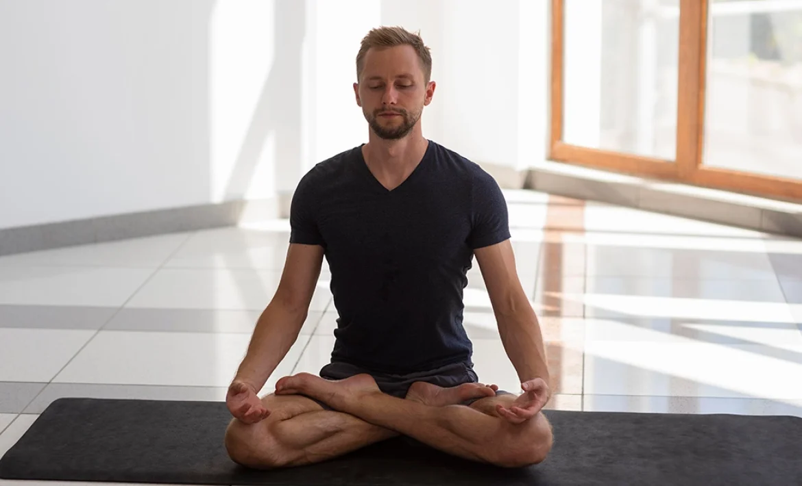 A yoga practitioner keeping a long, upright spine and level hips while demonstrating correct leg alignment in Padmasana.