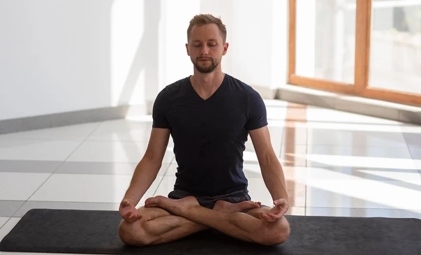A yoga practitioner keeping a long, upright spine and level hips while demonstrating correct leg alignment in Padmasana.