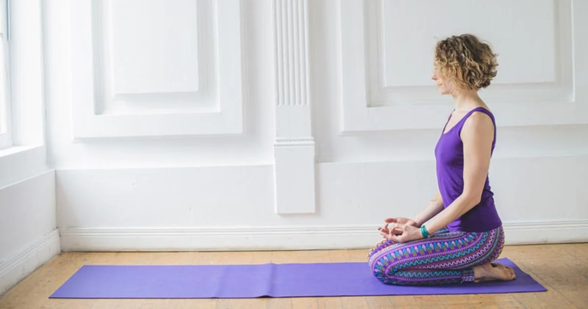 A yoga practitioner keeping an upright spine and stacked joints while demonstrating proper alignment in Vajrasana Thunderbolt Pose.