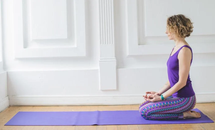 A yoga practitioner keeping an upright spine and stacked joints while demonstrating proper alignment in Vajrasana Thunderbolt Pose.
