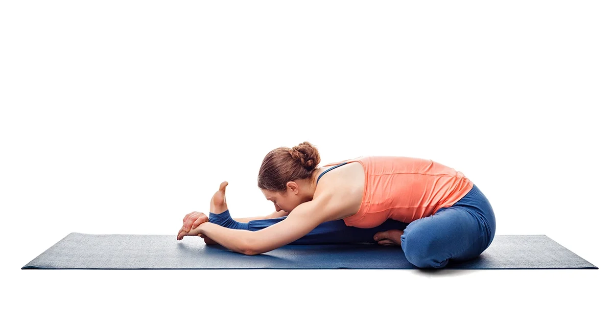 A yoga practitioner demonstrates proper chest rotation and safe knee alignment while holding Janushirsasana.