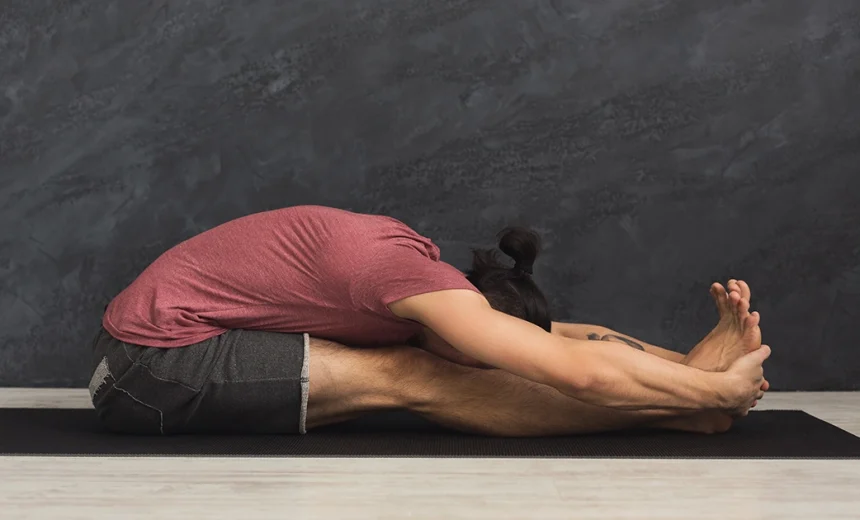 A yoga practitioner demonstrates proper pelvic tilting and safe spinal lengthening while holding Paschimottanasana.