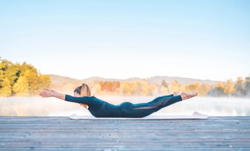 A yoga practitioner demonstrates elongated arms and legs lifted simultaneously in a balanced Viparita Shalabhasana arc.
