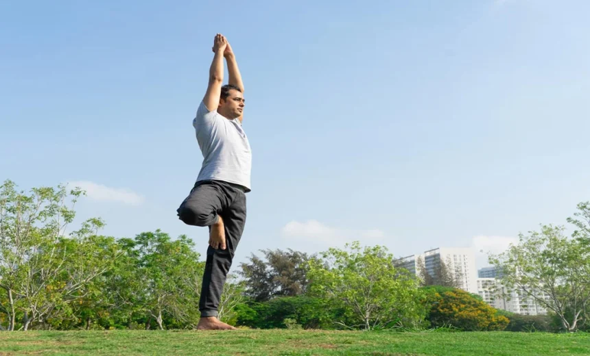 A yoga practitioner keeping proper alignment in Vriksasan Tree Pose by balancing on one leg with arms extended on a mat.