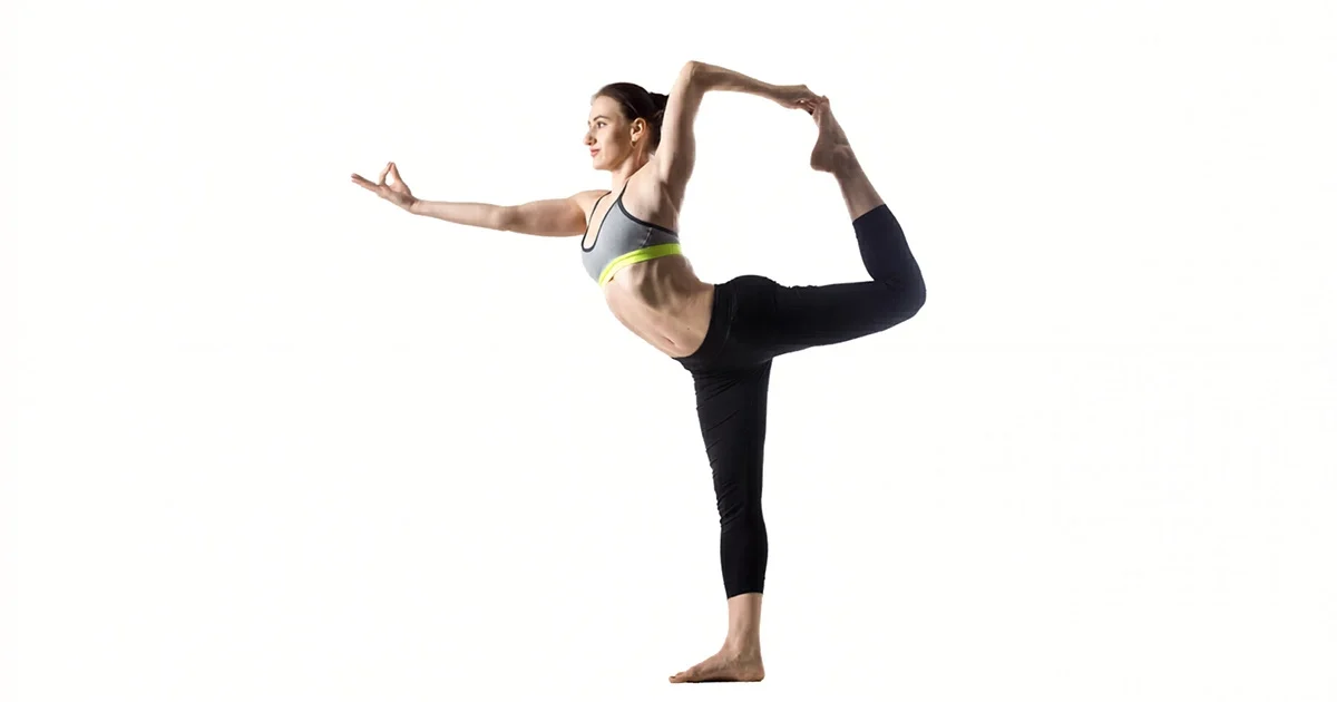 A yoga practitioner demonstrates perfect alignment in Natarajasana, focusing on a single point while extending the back leg into a graceful arc.