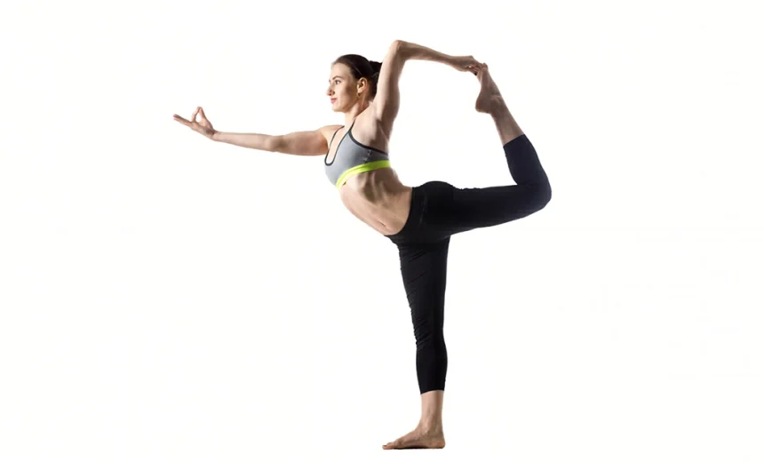 A yoga practitioner demonstrates perfect alignment in Natarajasana, focusing on a single point while extending the back leg into a graceful arc.