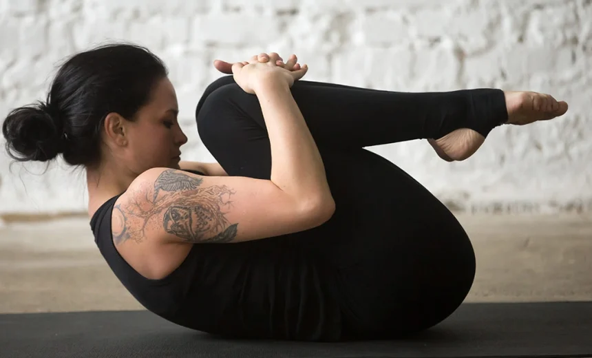 A yoga practitioner demonstrates a flat lower back and relaxed shoulders while holding Pawanmuktasana.