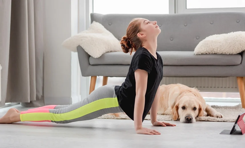 A practitioner demonstrates correct alignment in Urdhva Mukha Svanasana with active thighs lifted off the mat and shoulders stacked above the wrists.